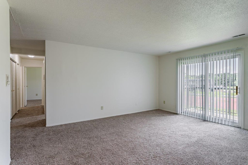 A room with white walls and carpeted floor.