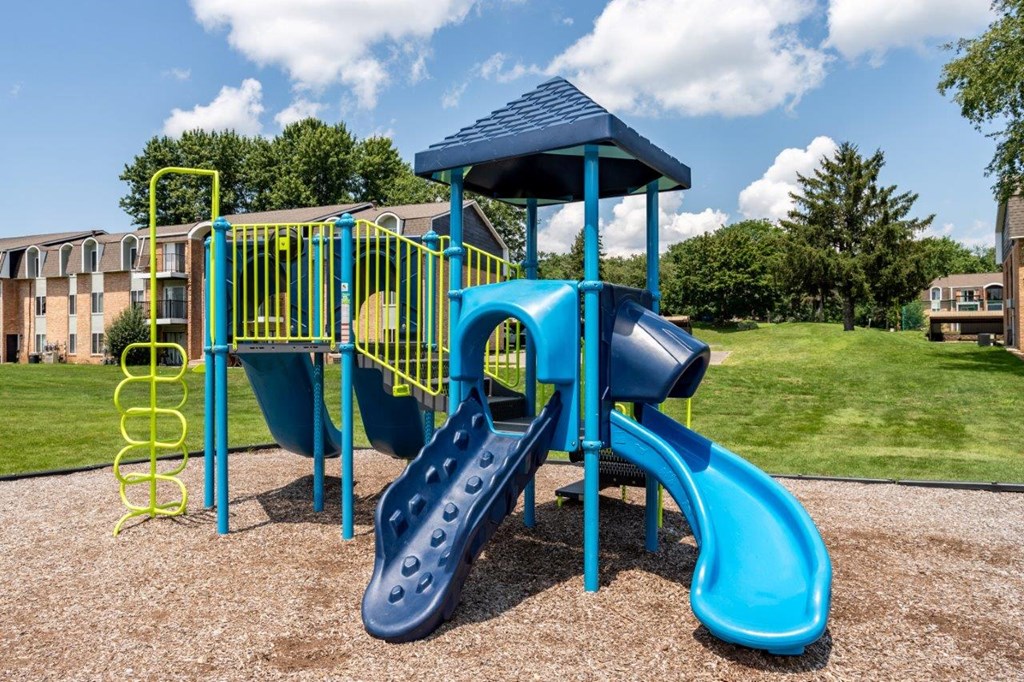 A blue and yellow playground with a slide and a tower.