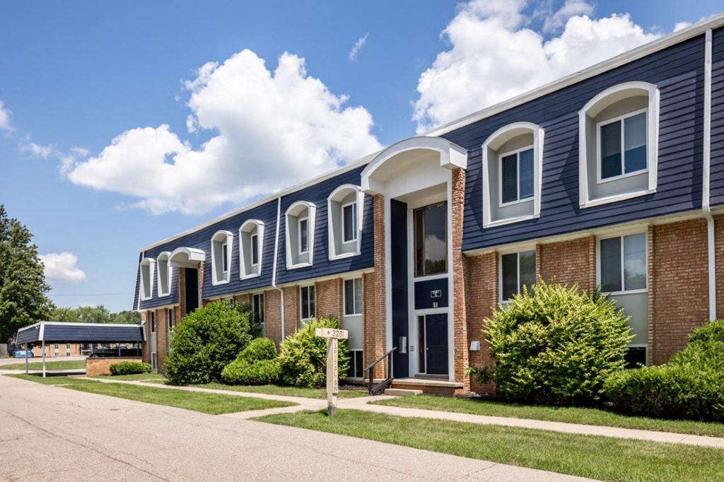A blue building with white windows and a white door.