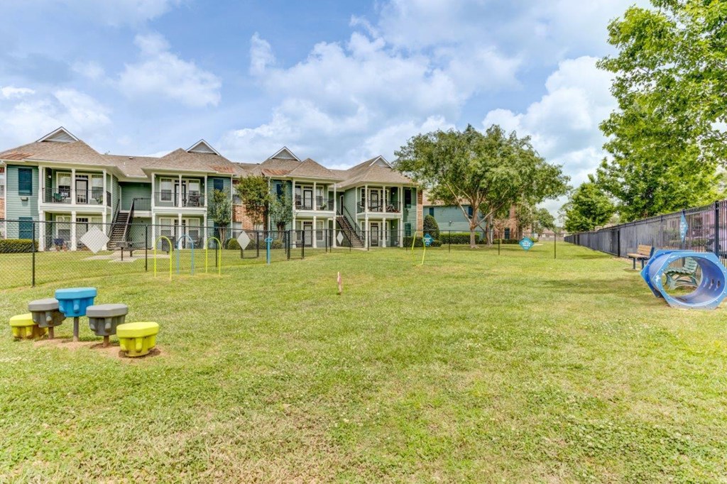 the backyard of an apartment building with a yard and a playground