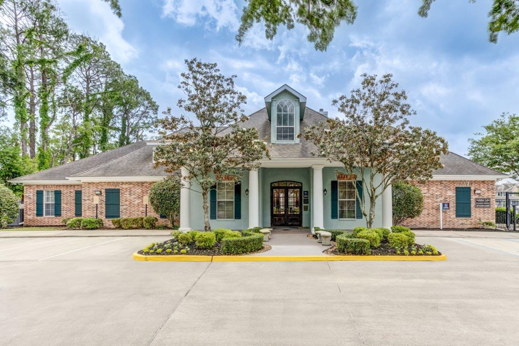 the front of a house with trees and a driveway