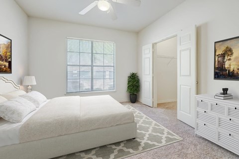 a bedroom with a white bed and a white dresser