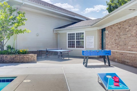 two ping pong tables in the back yard of a house with a pool