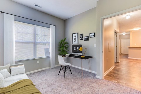 a home office with a desk and a large window