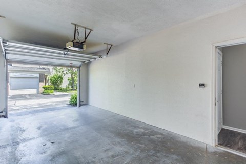 an empty garage with white walls and an open door