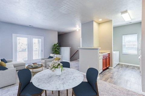 an open living room and kitchen with a table and chairs