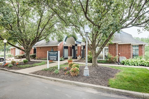 the front of a brick building with a sign on the sidewalk