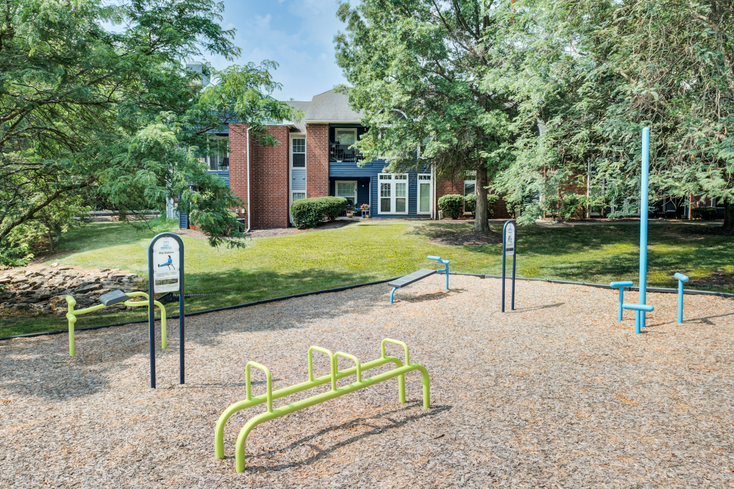 a park with playground equipment in front of a brick building
