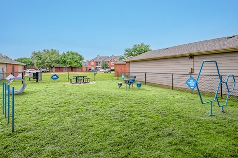 a yard with a playground and a chain link fence