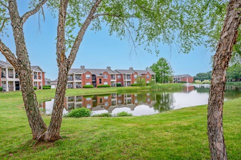 a pond in front of a building with trees