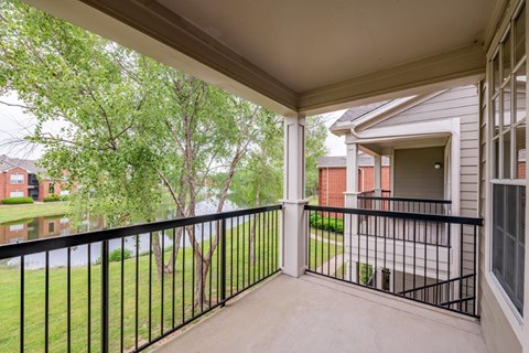 a balcony with a view of a yard and a house