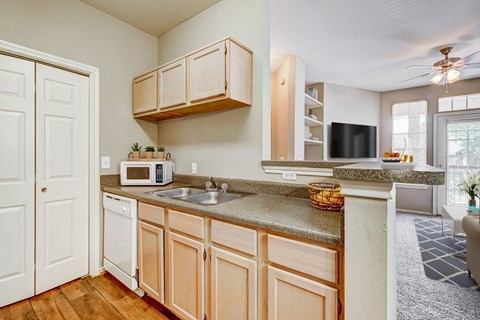 a kitchen with white cabinets and granite counter tops and a sink