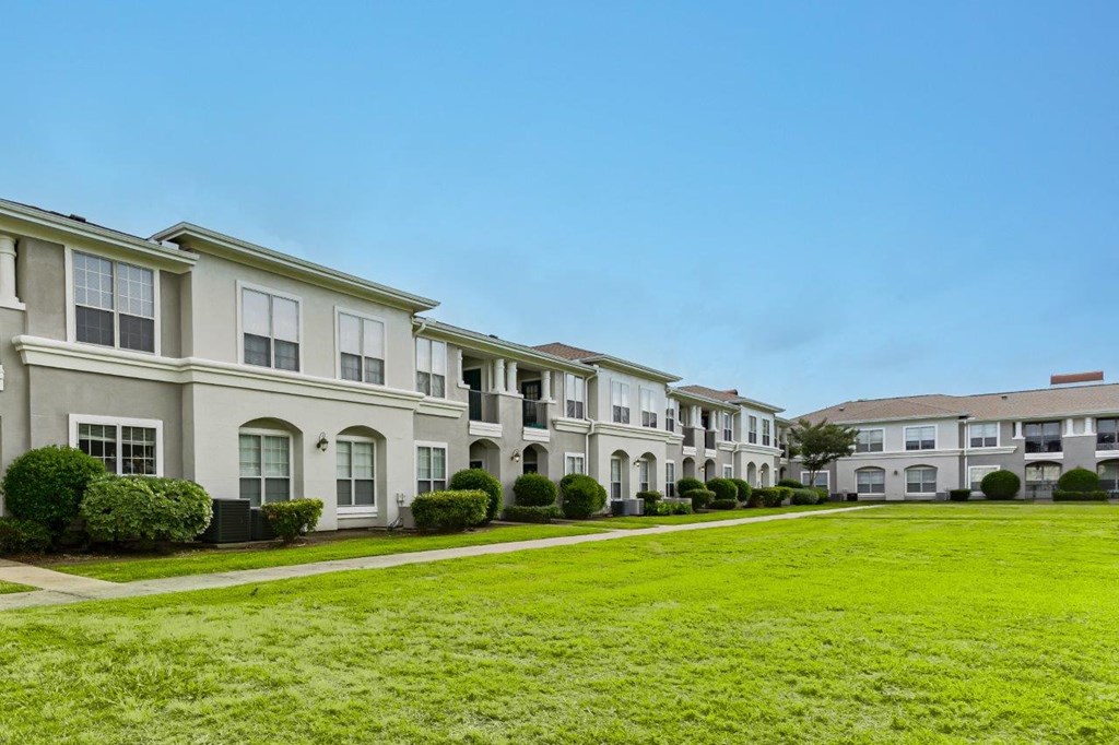 a row of town homes with a green lawn