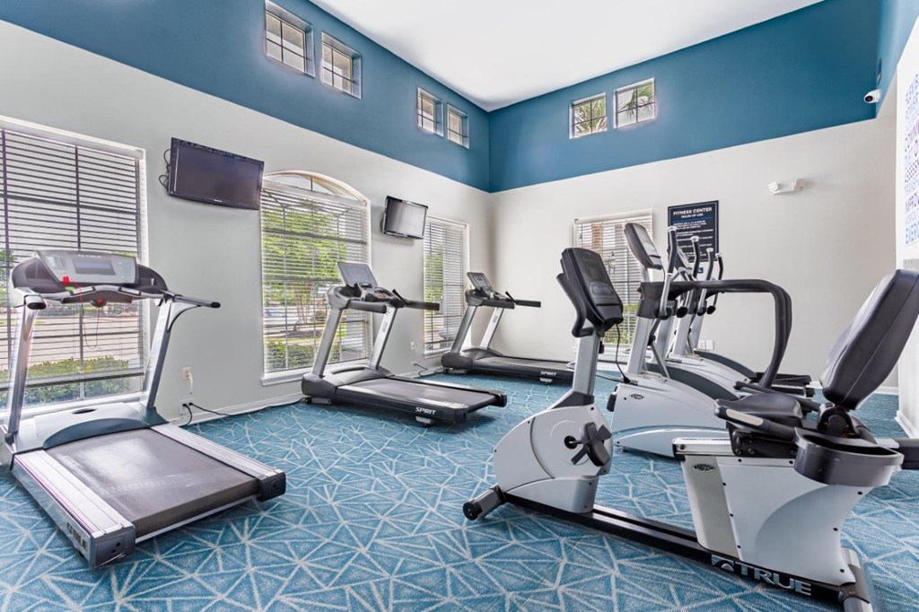 a gym with exercise equipment and windows
