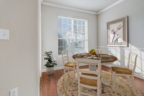 a dining room with a table and chairs and a window