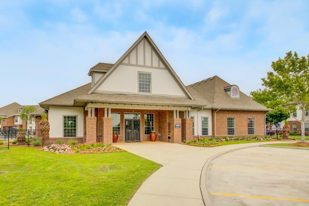 the front of a house with a driveway and lawn