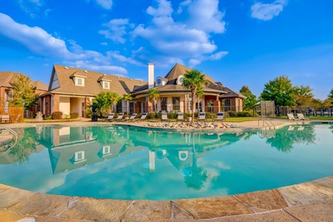 a large swimming pool with a house in the background