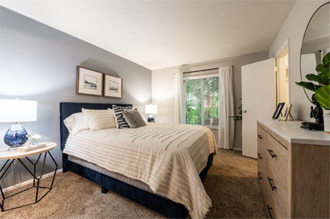 a bedroom with a bed and a dresser and a window