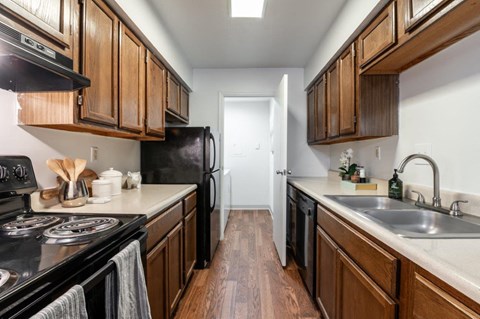 a kitchen with wooden cabinets and a stove and a sink