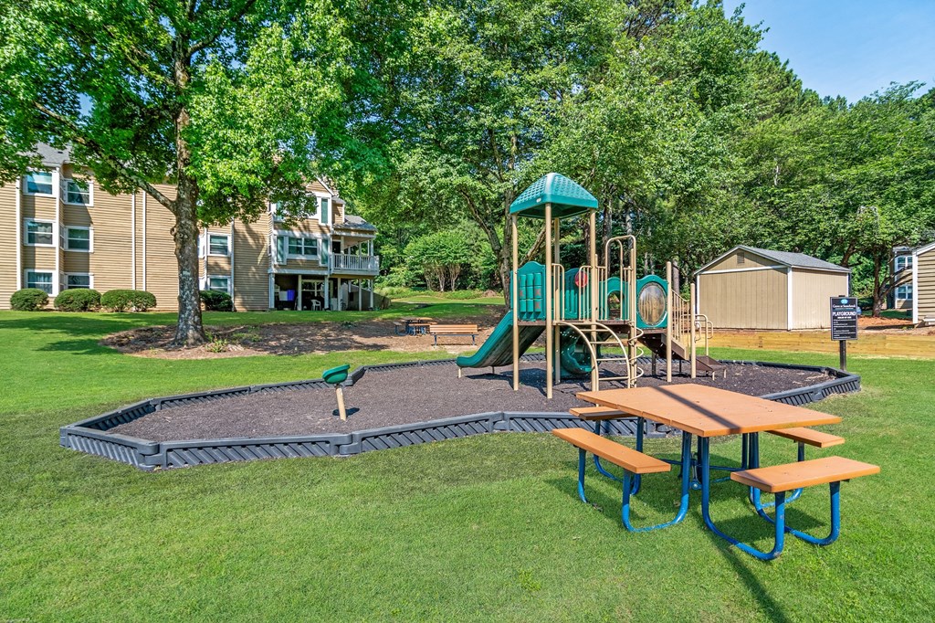 a playground with a swing set and a picnic table