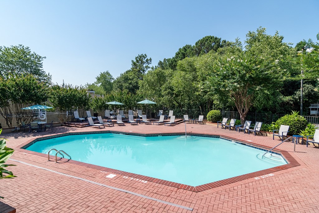 a swimming pool with chairs and umbrellas at the resort