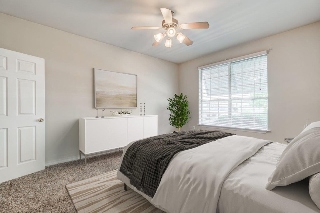 a bedroom with a bed and a ceiling fan