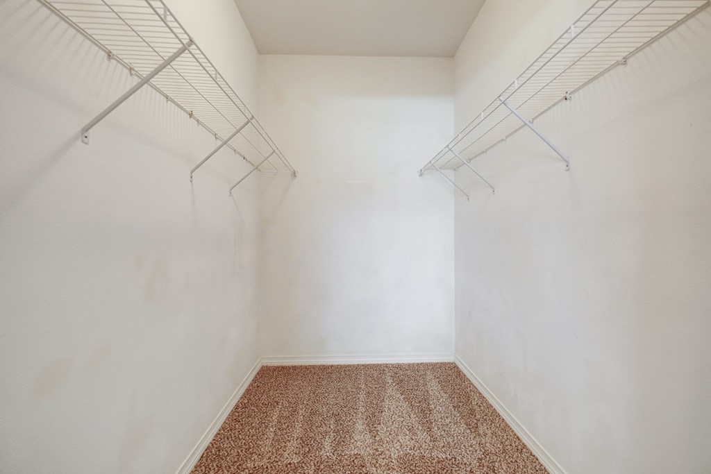 an empty room with white walls and two hanging racks on the wall