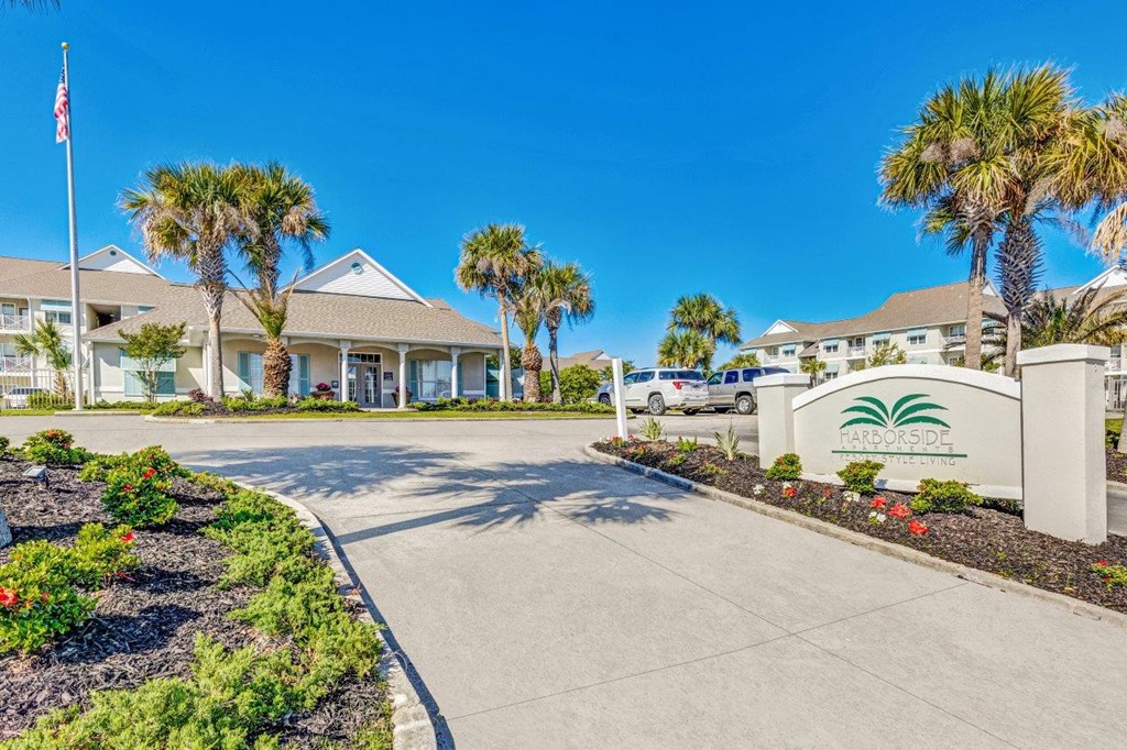 a building with palm trees and a driveway in front of it