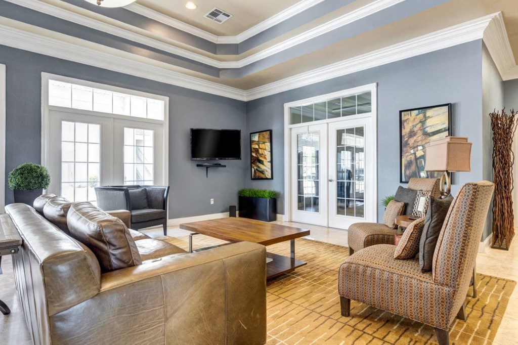 a living room with a couch and chairs and a television