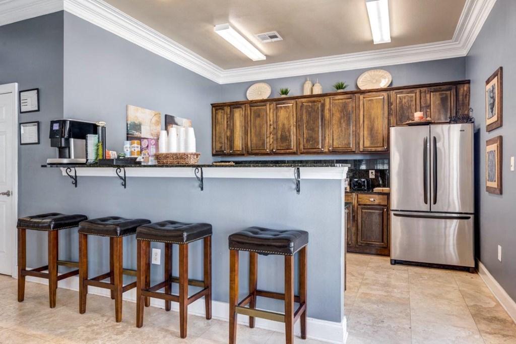a kitchen with a bar with three stools