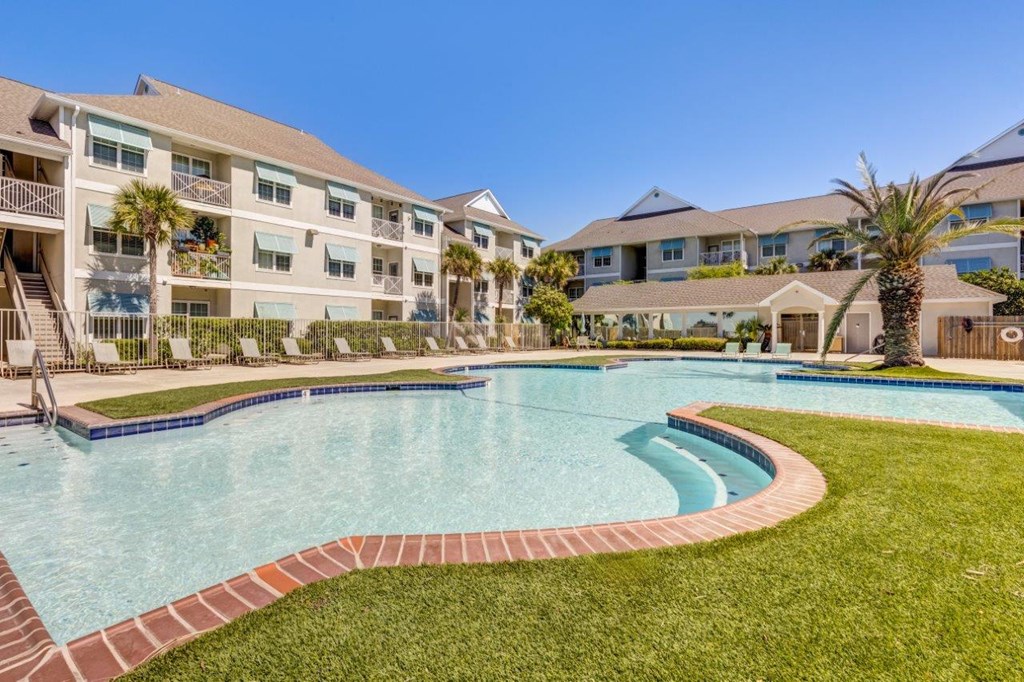 a large swimming pool with an apartment building in the background