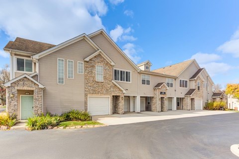 A large, modern house with a stone facade and multiple garages.