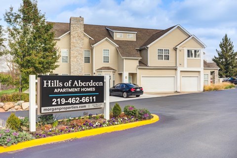A sign for the Hills of Aberdeen Apartment Homes is in front of a two-story building.