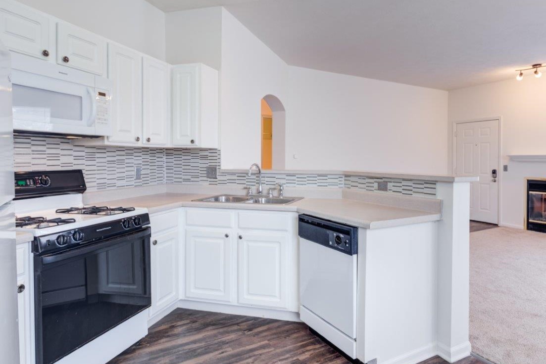 A kitchen with white cabinets and a black stove top.