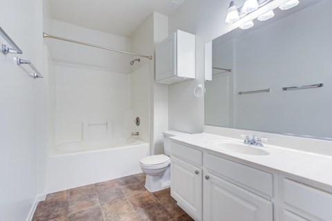 A white bathroom with a toilet, sink, and bathtub.