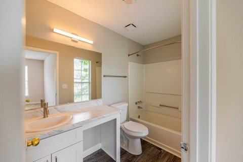 A bathroom with a sink, toilet, and bathtub.
