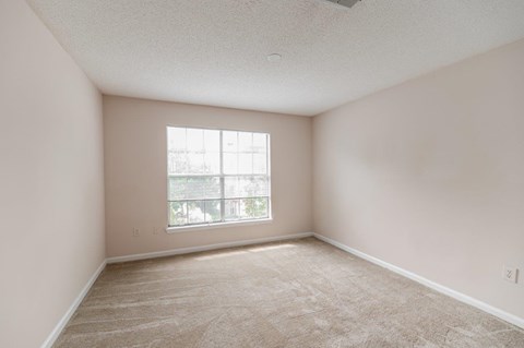 Empty room with a window and a ceiling fan.