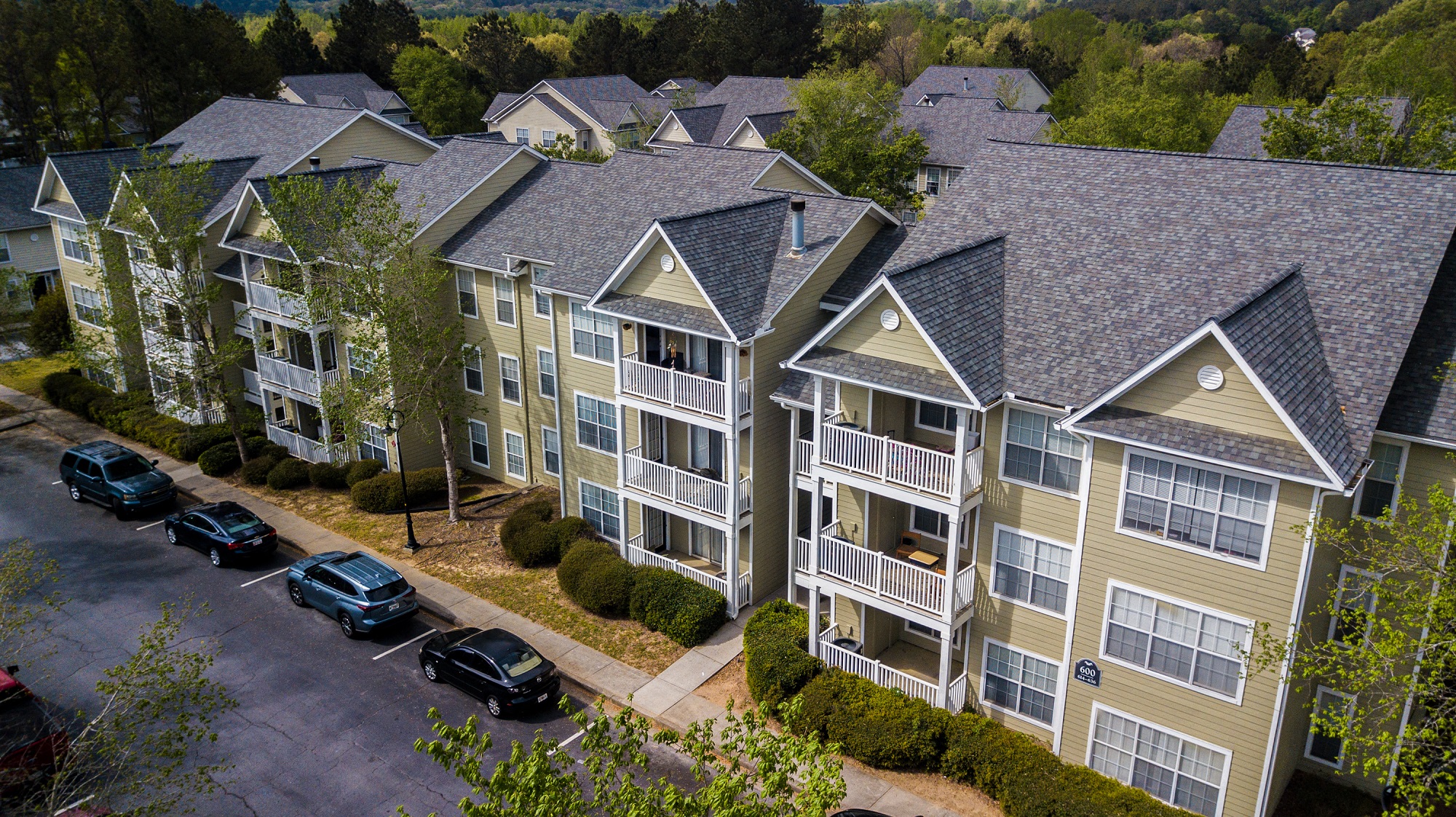 an aerial view of an apartment complex with cars parked outside