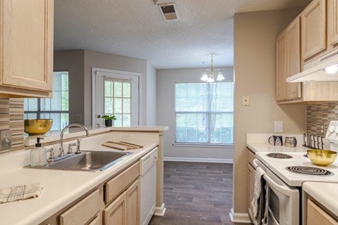 A kitchen with a white counter top and wooden cabinets.