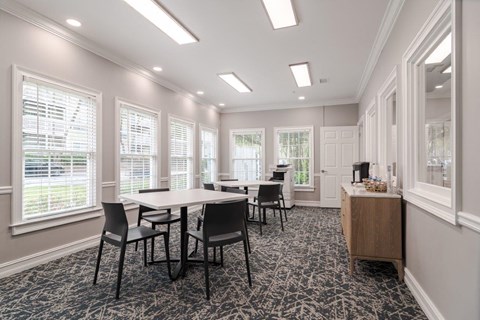 A room with a table and chairs and a patterned carpet.