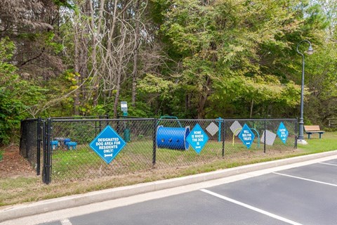 A sign on a fence indicates a designated dog area for dogs only.