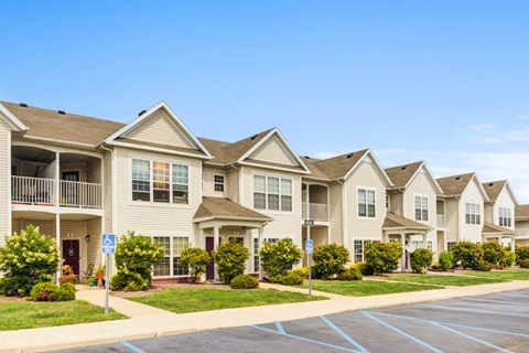 A row of townhouses with a blue sign in front of the first one.