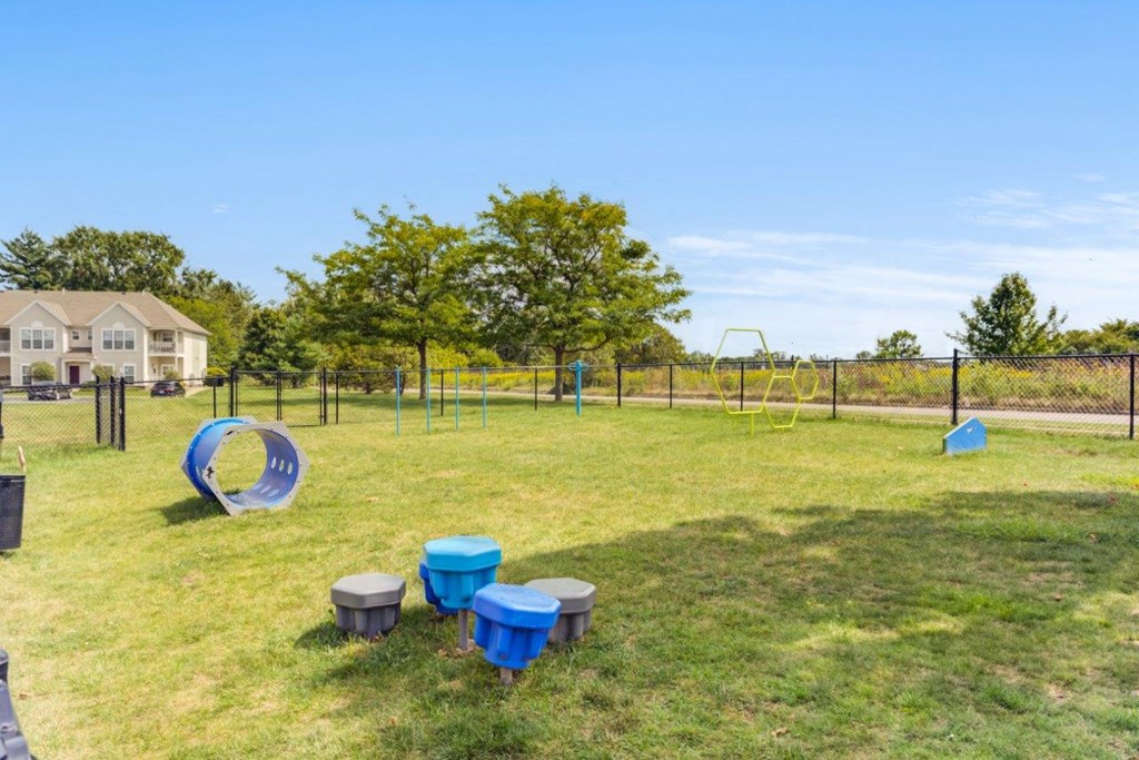 A playground with a slide, swings, and a fence.