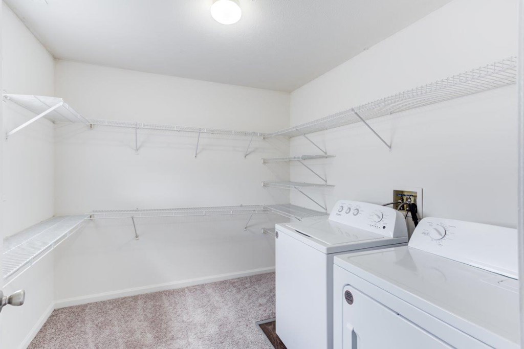 A white laundry room with a washer and dryer.