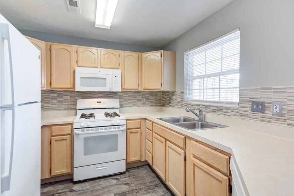 A kitchen with wooden cabinets and white appliances.