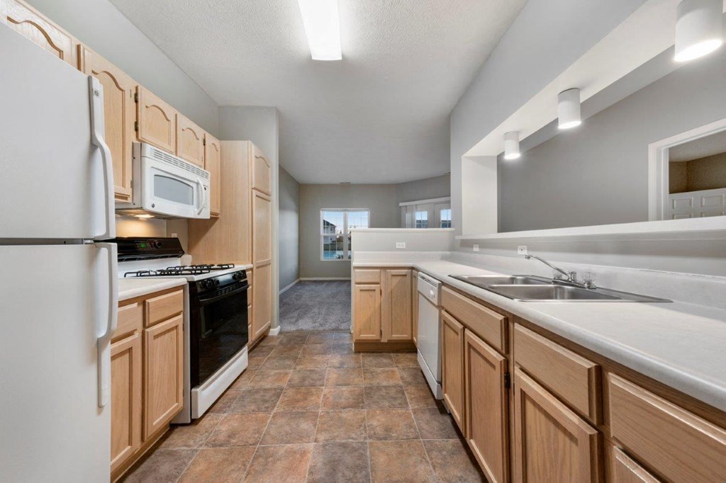 A kitchen with wooden cabinets and a white refrigerator.