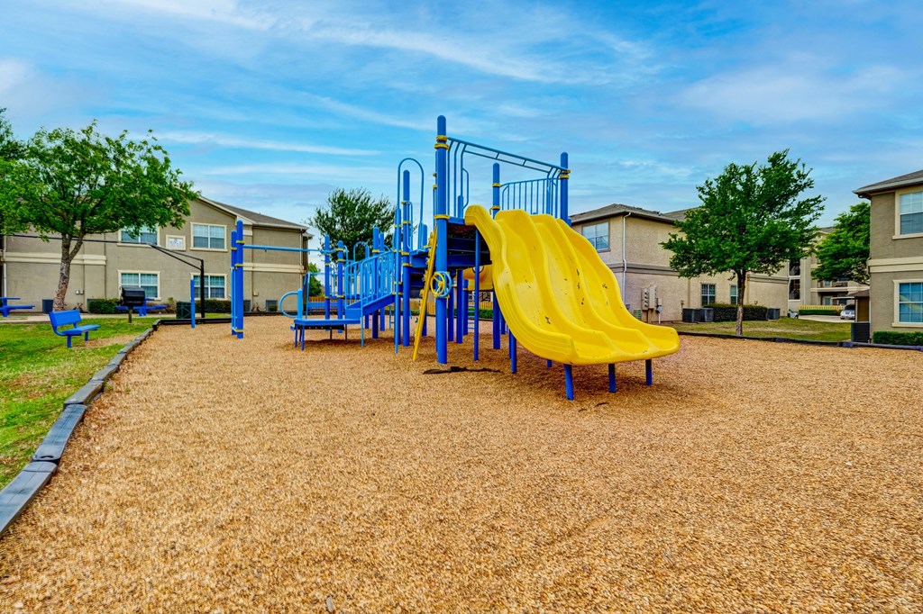 our apartments have a playground with a slide and benches