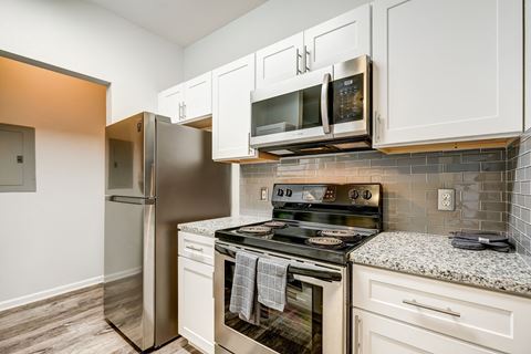 an updated kitchen with stainless steel appliances and white cabinets
