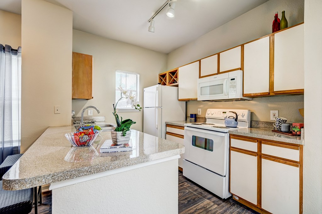 a kitchen with white appliances and granite counter tops