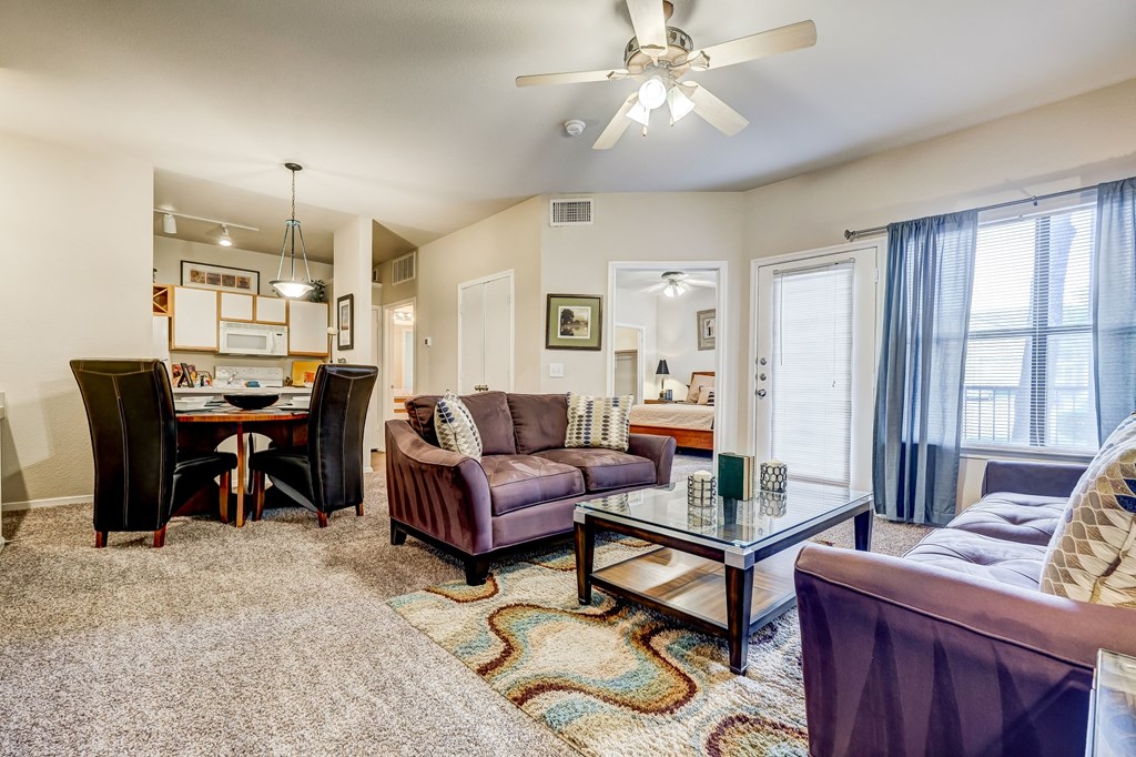 a living room with couches and chairs and a dining room table